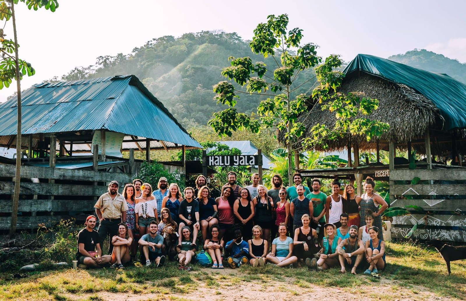 Group photo of residents and visitors gathered at the Kalu Yala village entrance